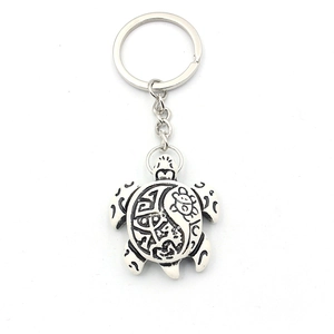 Porte-clés tortue en résine avec motifs tribaux maoris sur la carapace, fond blanc pur