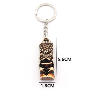 Detail view of bone-like resin Tiki keychain showing dimensions 5.6cm by 1.8cm