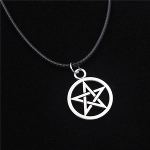 Zilveren pentagram hanger ketting met zwart gevlochten koord op donkere achtergrond