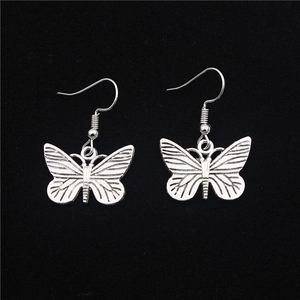 Elegant silver butterfly earrings set with detailed wing textures on a black background