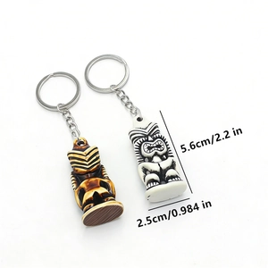 Detail showing two tiki totem keychains in brown and ivory with size 5.6cm measurements
