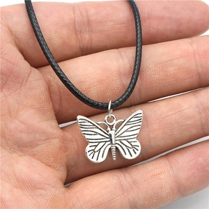 Butterfly pendant necklace with black woven cord and vintage alloy texture detail