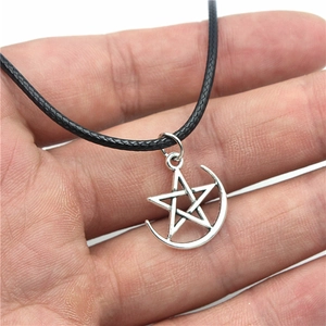 Collana vintage con ciondolo stella e luna argento e cordoncino nero in mano