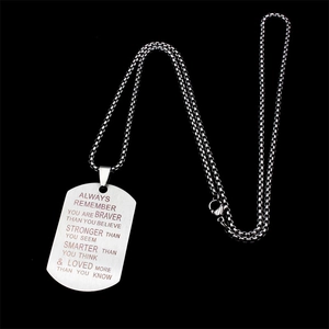 Détail macro de citations inspirantes gravées au laser sur un collier plaque d'identité