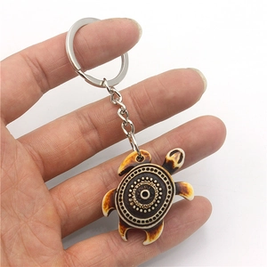 Ivory turtle keychain with tribal swirl pattern and brown burnt edges on silver ring