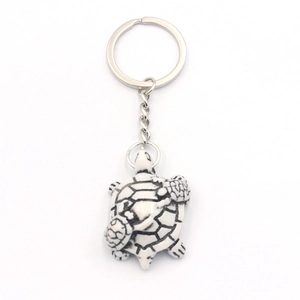 Resin sea turtle keychain featuring mother turtle carrying two babies on white background