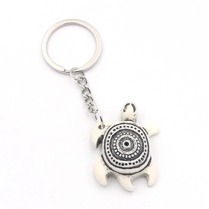 Tribal sea turtle keychain featuring black mandala swirl patterns on ivory resin shell