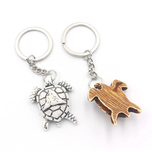 Turtle keychain set featuring white marbled resin and brown wood grain style pendants