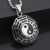 Detail of yin-yang puzzle necklace pendant with black and silver octagonal spider web design
