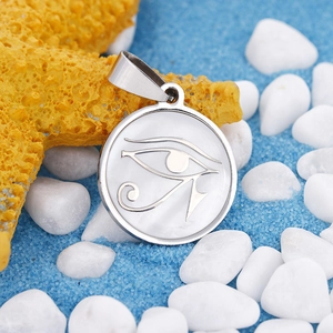 Polished stainless steel Eye of Horus pendant with white shell inlay on beach background