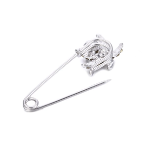 Elegante spilla a forma di tartaruga argentata con strass ambrati su sfondo bianco puro
