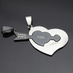 Detail of interlocking heart and arrow couple pendants in stainless steel with LOVE YOU engraving