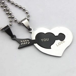 Detail of interlocking stainless steel heart and arrow couple necklaces with LOVE YOU engraving