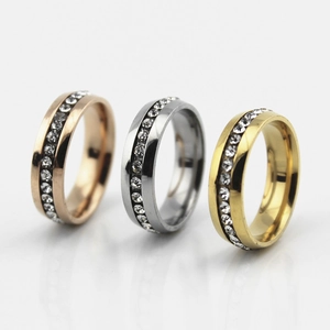 Three minimalist stainless steel rings with round cubic zirconia in gold, silver, and rose gold