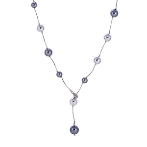 Détail d'un long collier en Y minimaliste avec perles sombres et pendentif cœur diamant