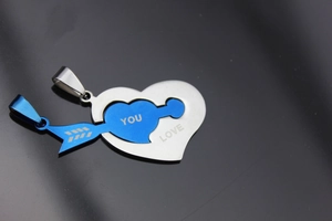 Macro detail of stainless steel interlocking heart pendant with Love You engraving