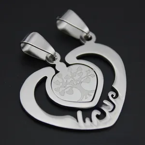 Macro shot of silver stainless steel heart couple pendant with tree of life engraving