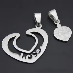 Close-up of heart pendants featuring a laser-engraved tree of life on silver stainless steel