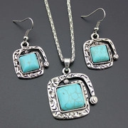 Macro detail of vintage hammered silver necklace and earrings set with turquoise stones