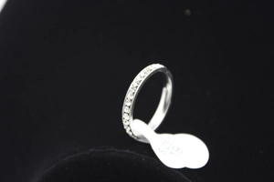 Detail macro shot of a size 19 silver steel ring with a single row of sparkling crystals