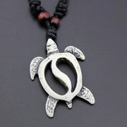 Macro shot of retro turtle pendant with Yin Yang motif on black braided cord