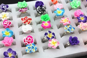 Detailed top view of colorful clay flower rings in diverse styles on a display tray