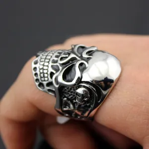 Detailed close-up of a punk-style skull ring in retro silver stainless steel on a finger