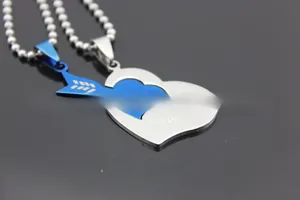 Detail of interlocking stainless steel heart and arrow couple necklaces with LOVE YOU engraving