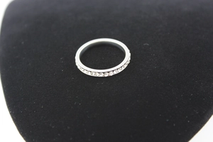Detailed macro shot of a silver stainless steel eternity ring with rows of clear zircon crystals