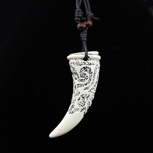 Collier dent de loup tribal avec gravures vintage et corde tressée noire sur fond sombre