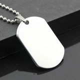 Detailed view of a polished stainless steel dog tag pendant with a silver ball chain