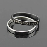 Macro shot of interlocking black and silver rings with I Love You laser engraving