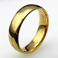Macro shot of the polished golden ring featuring intricate Elvish script engravings