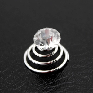 Detailed macro view of a silver spiral hair screw featuring a large faceted clear rhinestone