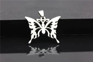 Detailed macro view of hollow butterfly pendant with flame patterns on reflective surface