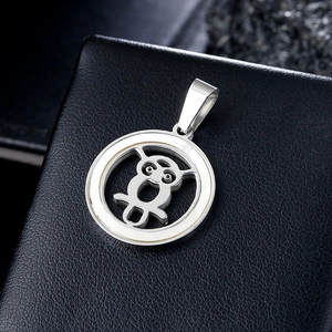 Polished stainless steel owl pendant with hollow design on black leather surface
