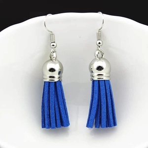 Close-up of bohemian royal blue suede tassel earrings with polished silver metal caps