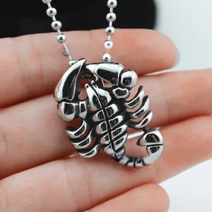 Gros plan sur un pendentif scorpion vintage en acier inoxydable argenté avec chaîne