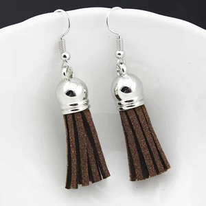 Close-up of bohemian style silver bell earrings with deep brown faux suede tassels