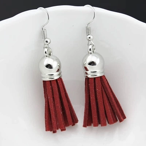 Detail of deep red suede fringe earrings with metallic silver hook and polished cap