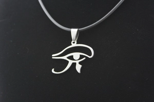 Macro detail of silver Eye of Horus stainless steel pendant on black cord necklace