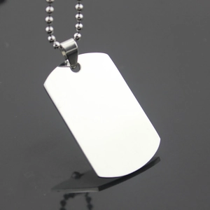 Polished stainless steel dog tag necklace with ball chain on black reflective surface