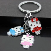 Close-up of Hello Kitty charms in red, blue, and pink on a polished silver metal keychain