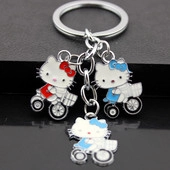 Close-up of enamel cartoon cat motorcycle charms on silver metal key ring set