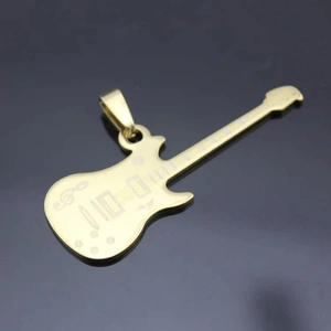 Vue détaillée du pendentif guitare doré avec gravure laser sur fond sombre