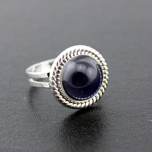 Macro-zijaanzicht van vintage zilveren ring met grote paarse edelsteen en touwrand detail