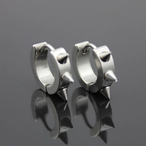 Punk style stainless steel hoop earrings with silver spikes on a reflective surface