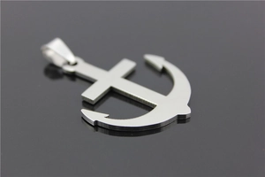 Detail view of a silver stainless steel anchor and cross pendant with matte metallic finish