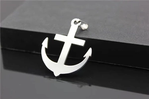 Macro shot of polished stainless steel anchor pendant with reflective mirror finish