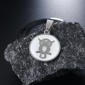 Fashionable stainless steel owl necklace with shell inlay on dark stone background